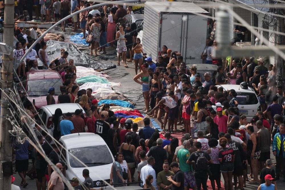 Residents look at the bodies of people killed the day before during a police raid targeting the Comando Vermelho gang at the Complexo da Penha favela in Rio de Janeiro, Brazil, Wednesday, Oct. 29, 2025. (AP Photo/Silvia Izquierdo)