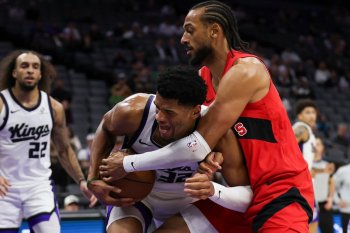 Sacramento Kings center Dylan Cardwell, left, and Toronto Raptors forward Olivier Sarr, right, battle for the ball during the second half of an NBA basketball preseason game Wednesday, Oct. 8, 2025, in Sacramento, Calif. (AP Photo/Scott Marshall)