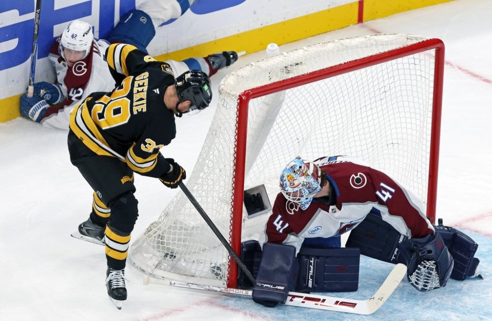 Boston Bruins forward Morgan Geekie stuffs the puck past Colorado Avalanche goalie Scott Wedgewood to score with five seconds remaining in the second period as Colorado defenceman Josh Manson watches in the background during a hockey game, Oct. 25, 2025, in Boston. (AP Photo/Jim Davis)
