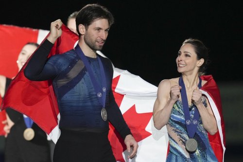 Silver medalists Deanna Stellato-Dudek, right, and Maxime Deschamps of Canada carry their national flag during victory ceremonies of the pairs free skating at the ISU Four Continents Figure Skating Championships at the Mokdong ice rink in Seoul, South Korea, Friday, Feb. 21, 2025. (AP Photo/Lee Jin-man)