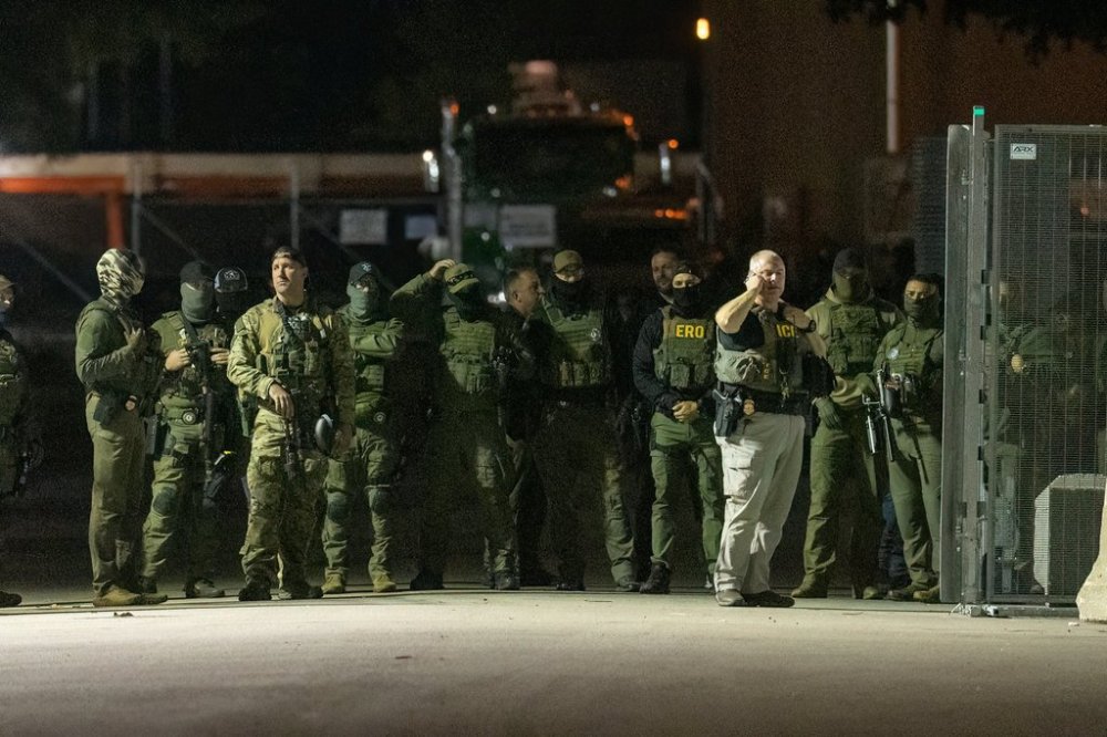 Federal law enforcement officers stand guard in the open gate of the fence built on Beach Street outside the Broadview ICE processing facility in suburban Broadview, Tuesday, Oct. 14, 2025. (Tyler Pasciak LaRiviere/Chicago Sun-Times via AP)