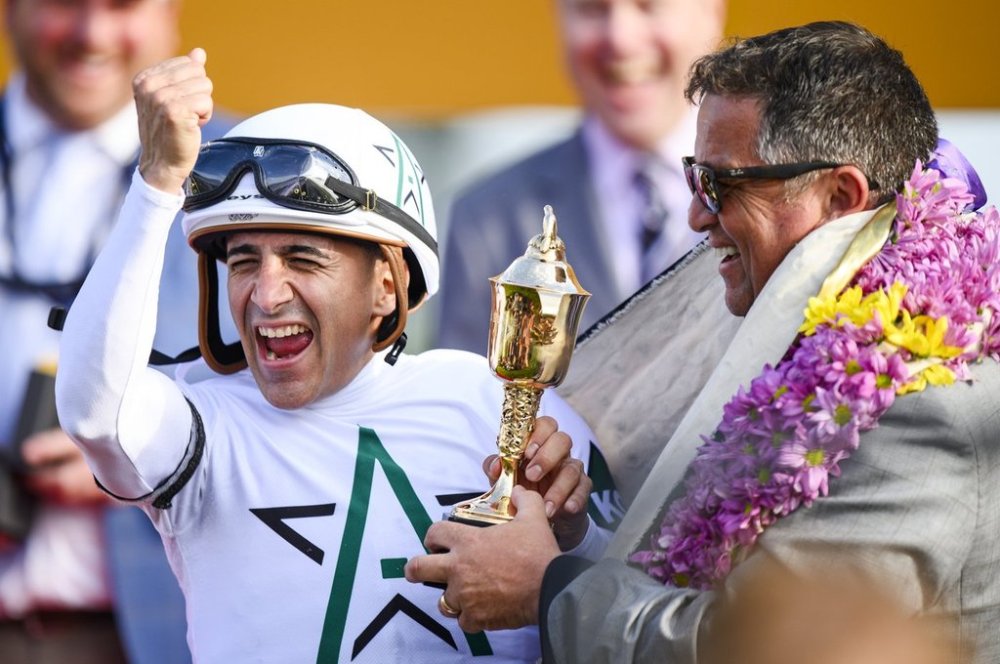 Jockey Rafael Hernandez (left) and trainer Kevin Attard celebrate their win with the trophy during the 165th running of the King's Plate horse race in Toronto on Friday, August 23, 2024. THE CANADIAN PRESS/Christopher Katsarov