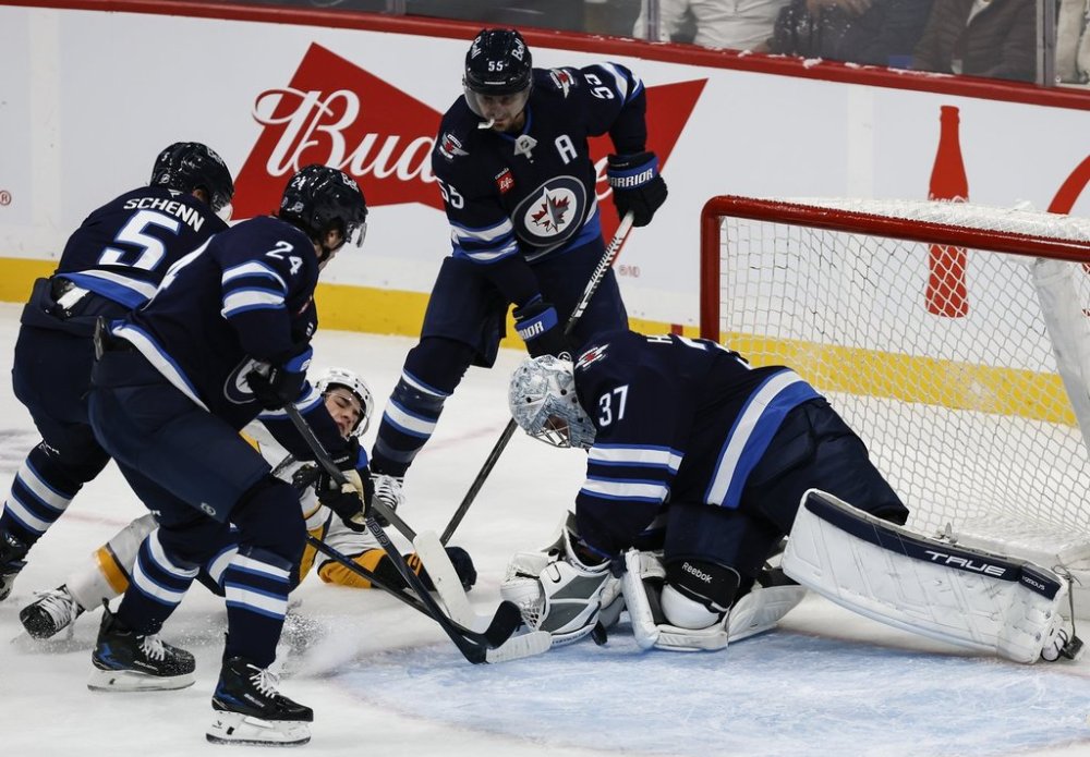 Winnipeg Jets goaltender Connor Hellebuyck (37) saves the shot from Nashville Predators' Luke Evangelista (77) during first period NHL action in Winnipeg on Saturday, Oct. 18, 2025. THE CANADIAN PRESS/John Woods