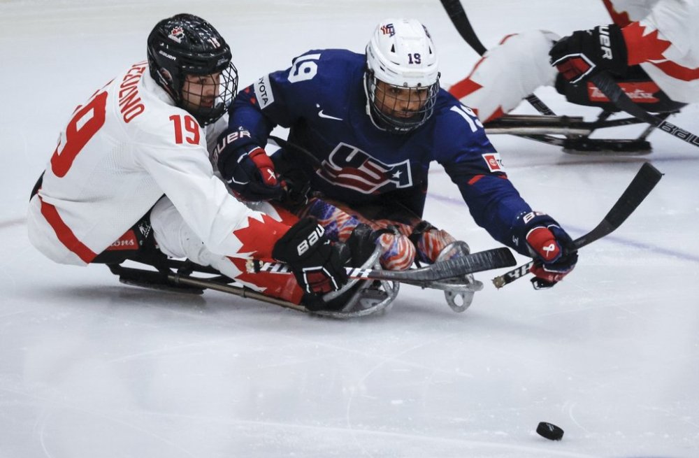 Team USA forward Malik Jones (19) is checked by Team Canada forward Dominic Cozzolino (19) during second period action in the World Para Ice Hockey Championship final in Calgary, Sunday, May 12, 2024. THE CANADIAN PRESS/Jeff McIntosh