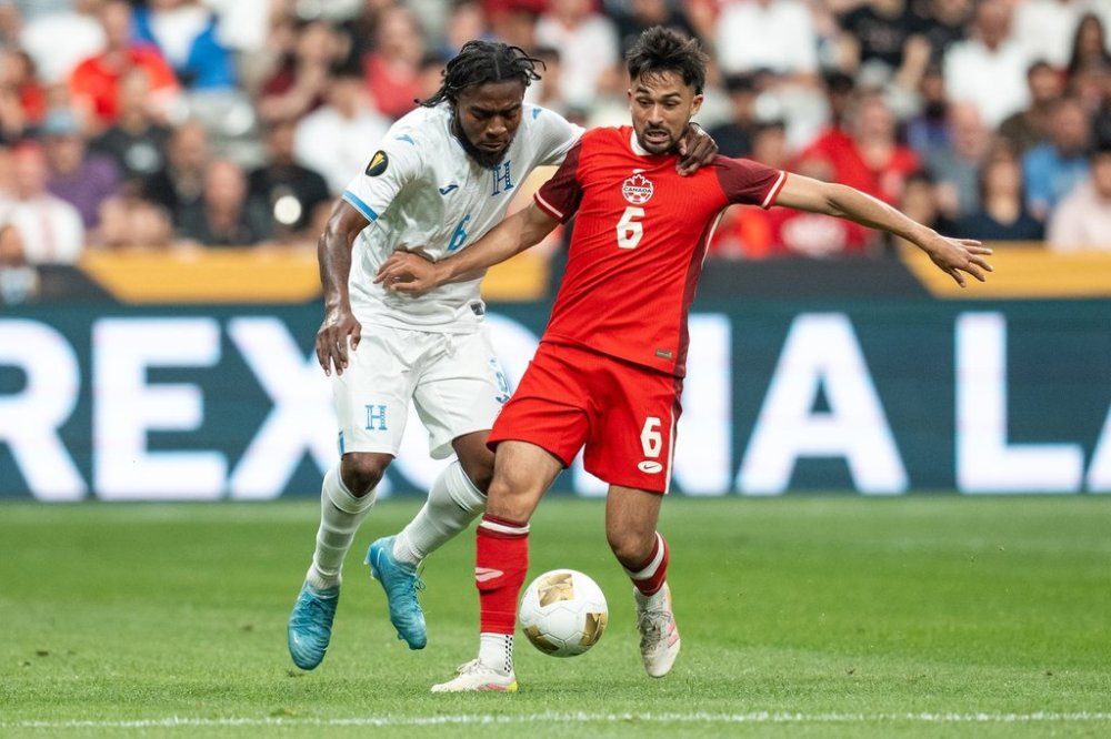 Honduras' Cristopher Melendez, left, and Canada's Mathieu Choiniere (6) vie for the ball during the first half of a CONCACAF Gold Cup soccer match in Vancouver, on Tuesday, June 17, 2025. THE CANADIAN PRESS/Ethan Cairns