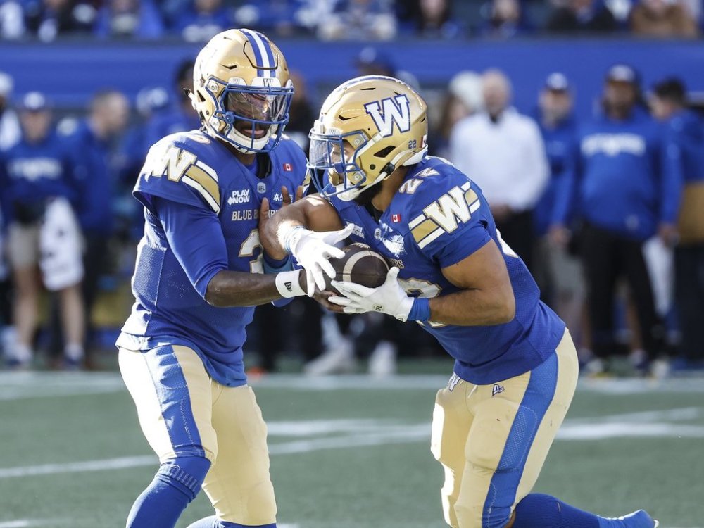 Winnipeg Blue Bombers quarterback Terry Wilson (3) hands off to Matthew Peterson (22) during first half CFL action against the Montreal Alouettes in Winnipeg, Saturday, Oct. 25, 2025. THE CANADIAN PRESS/John Woods