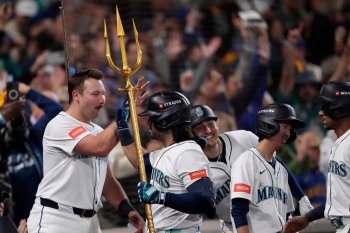 Seattle Mariners' Eugenio Suárez holds the trident after hitting a grand slam home run during the eighth inning in Game 5 of baseball's American League Championship Series against the Toronto Blue Jays, Friday, Oct. 17, 2025, in Seattle. (AP Photo/Lindsey Wasson)