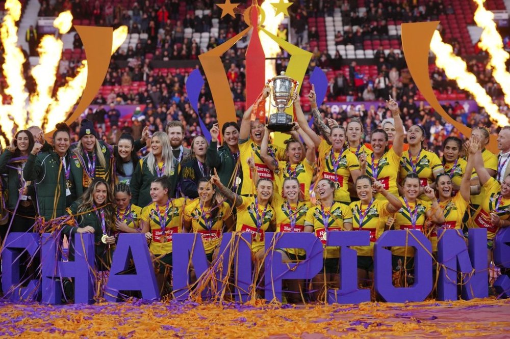 Australia's players celebrate with the trophy after winning during the Women's Rugby League World Cup final match between Australia and New Zealand at the Old Trafford stadium in Manchester, England, Saturday, Nov. 19, 2022. (AP Photo/Jon Super)
