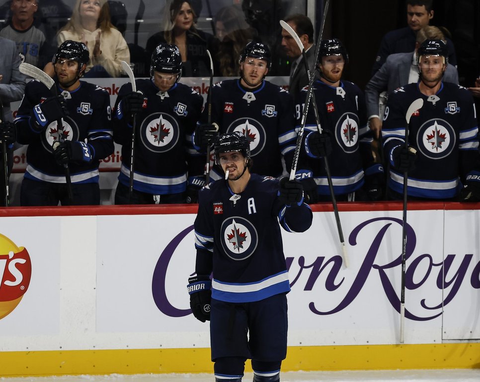 Winnipeg Jets' Mark Scheifele (55) raises his stick to the crowd as he is announced as franchise point leader during first period NHL action against the Nashville Predators in Winnipeg on Saturday, October 18, 2025. THE CANADIAN PRESS/John Woods