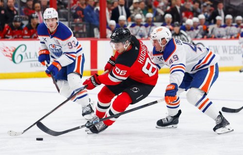 CORRECTS YEAR TO 2025, NOT 2024 - New Jersey Devils center Jack Hughes (86) plays the puck against Edmonton Oilers defenseman Ty Emberson (49) and center Ryan Nugent-Hopkins (93) during the second period of an NHL hockey game, Saturday, Oct. 18, 2025, in Newark, N.J. (AP Photo/Noah K. Murray)