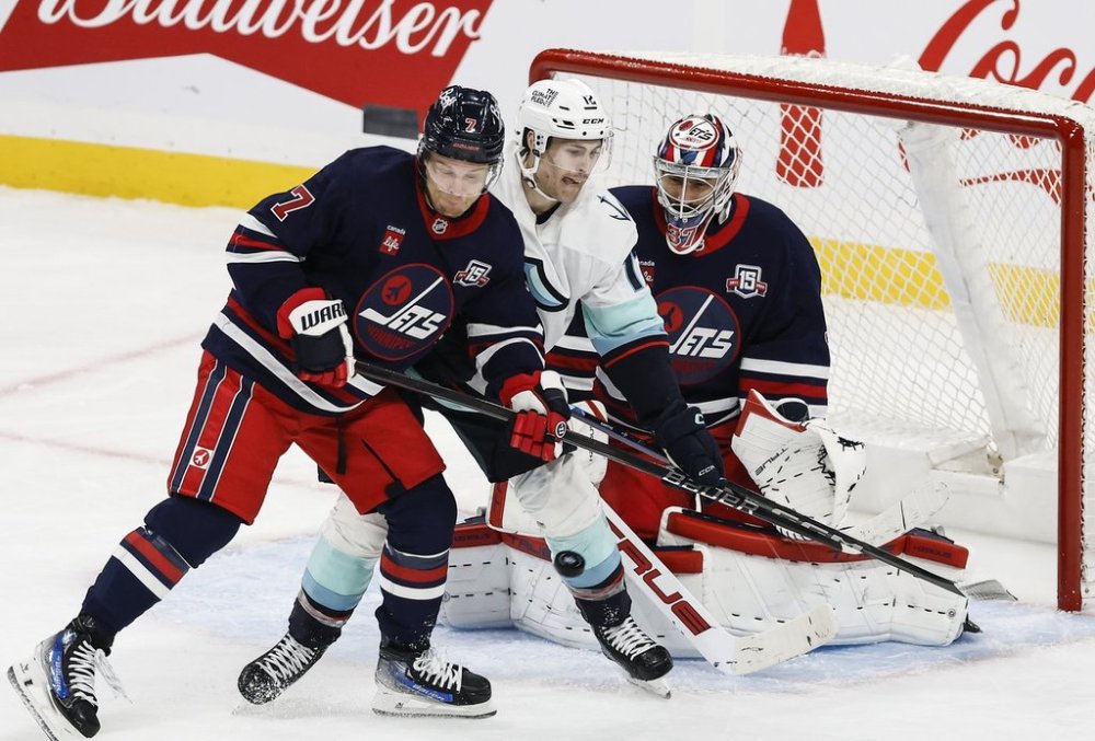 Winnipeg Jets' Vladislav Namestnikov (7) defends against Seattle Kraken's Matty Beniers (10) in front of goaltender Connor Hellebuyck (37) during first period NHL action in Winnipeg on Thursday, October 23, 2025. THE CANADIAN PRESS/John Woods