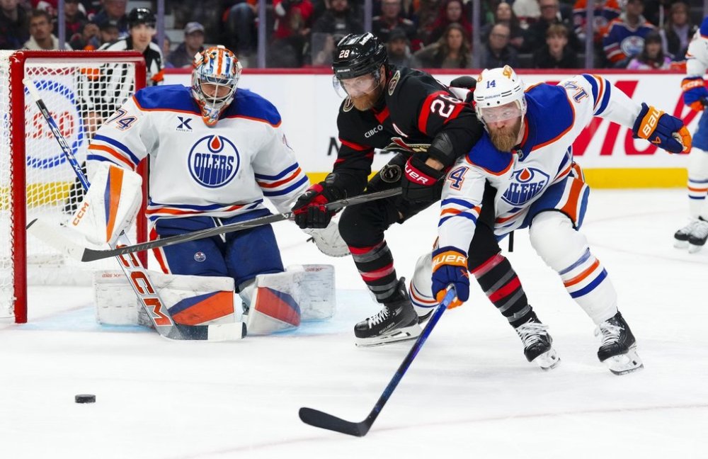Edmonton Oilers' goaltender Stuart Skinner (74) keeps his eye on the puck as Edmonton Oilers' Mattias Ekholm (14) and Ottawa Senators' Claude Giroux (28) battle it out during second period NHL hockey action in Ottawa on Tuesday, Oct. 21, 2025. THE CANADIAN PRESS/Sean Kilpatrick