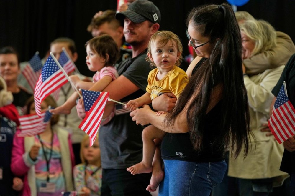 FILE - Afrikaner refugees from South Africa holding American flags arrive, May 12, 2025, at Dulles International Airport in Dulles, Va. (AP Photo/Julia Demaree Nikhinson, File)