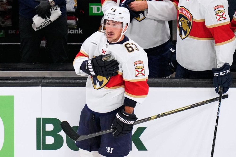 Florida Panthers left wing Brad Marchand (63), who played for more than 15 seasons with the Boston Bruins, taps his heart during a standing ovation during a break in the first period of an NHL hockey game, Tuesday, Oct. 21, 2025, in Boston. (AP Photo/Charles Krupa)