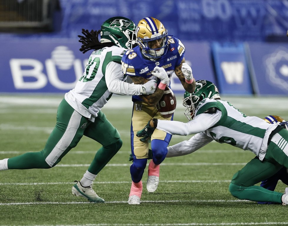 Winnipeg Blue Bombers’ Trey Vaval (23) fumbles the ball as he is tackled on the opening kick return by Saskatchewan Roughriders’ Kerfalla Exumé (20) during first half CFL action in Winnipeg, Friday, Oct. 17, 2025. THE CANADIAN PRESS/John Woods