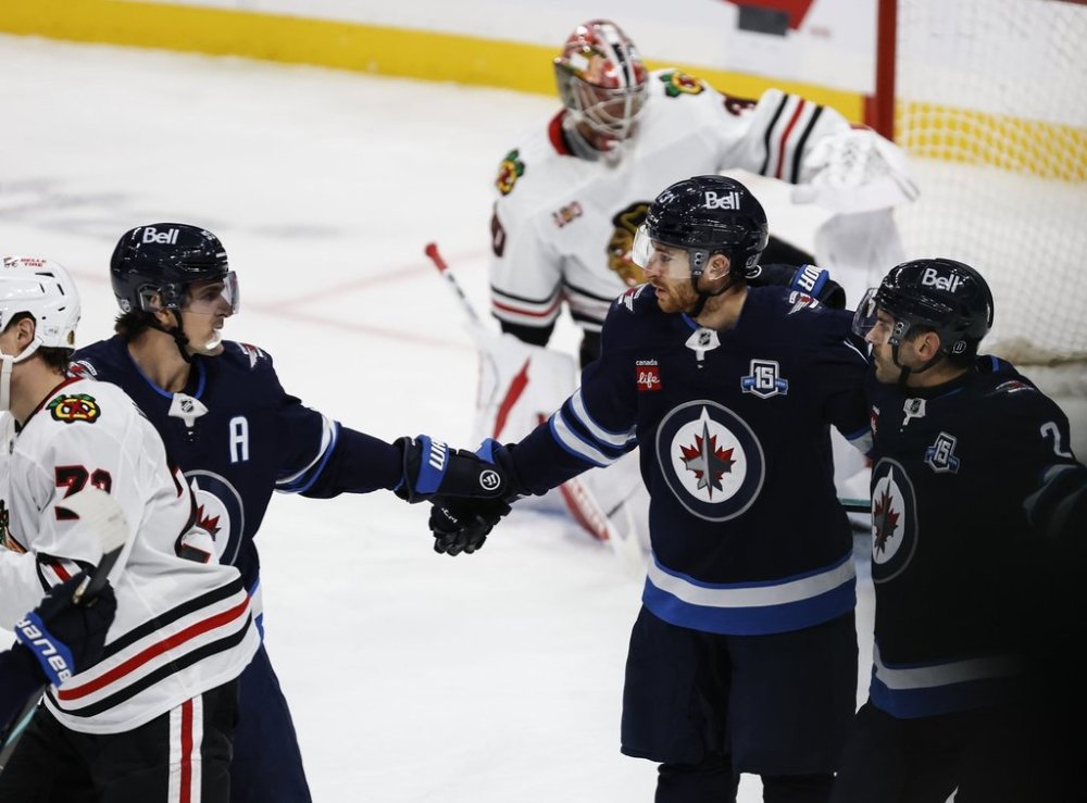 Winnipeg Jets' Mark Scheifele (55) and Dylan DeMelo (2) celebrate Gabriel Vilardi's (13) goal against the Chicago Blackhawks during second period NHL action in Winnipeg on Thursday, October 30, 2025. THE CANADIAN PRESS/John Woods