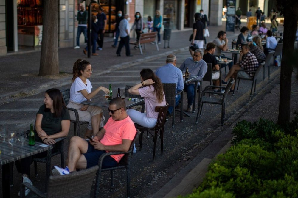 FILE - Customers sit at a terrace bar in Girona, Spain, on May 18, 2020. (AP Photo/Emilio Morenatti, File)