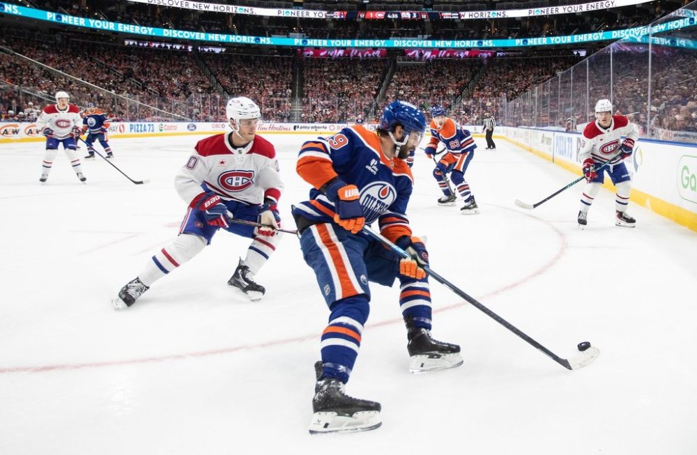 Montreal Canadiens' Juraj Slafkovsky (left) chases Edmonton Oilers' Adam Henrique (19) during second period NHL action, in Edmonton on Thursday, October 23, 2025. THE CANADIAN PRESS/Jason Franson