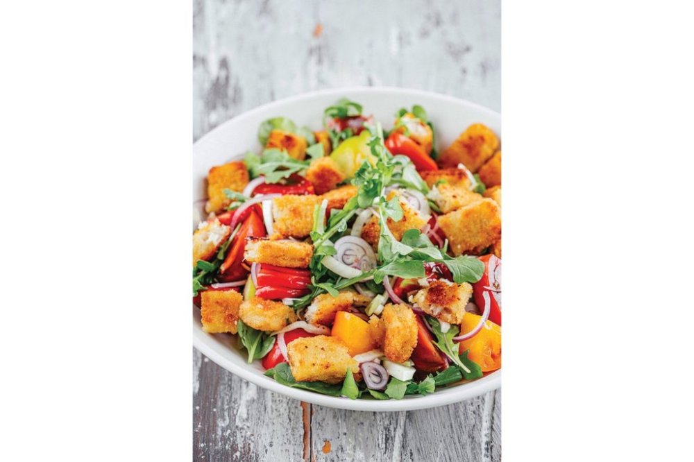 This image released by Harvest, an imprint of HarperCollins Publishers, shows a recipe for fish sticks on a rustic Italian salad called panzanella. (Eric Wolfinger/Harvest via AP)