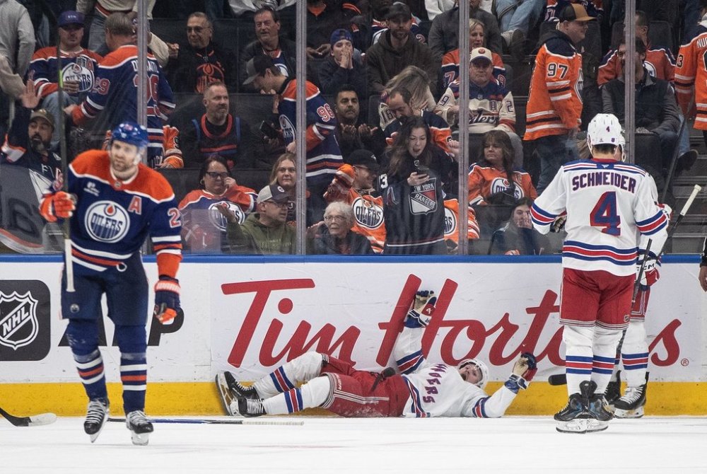 New York Rangers' J.T. Miller (8) and Braden Schneider (4) celebrate a goal as Edmonton Oilers' Leon Draisaitl (29) skates away during overtime NHL action, in Edmonton on Thursday, October 30, 2025. THE CANADIAN PRESS/Jason Franson
