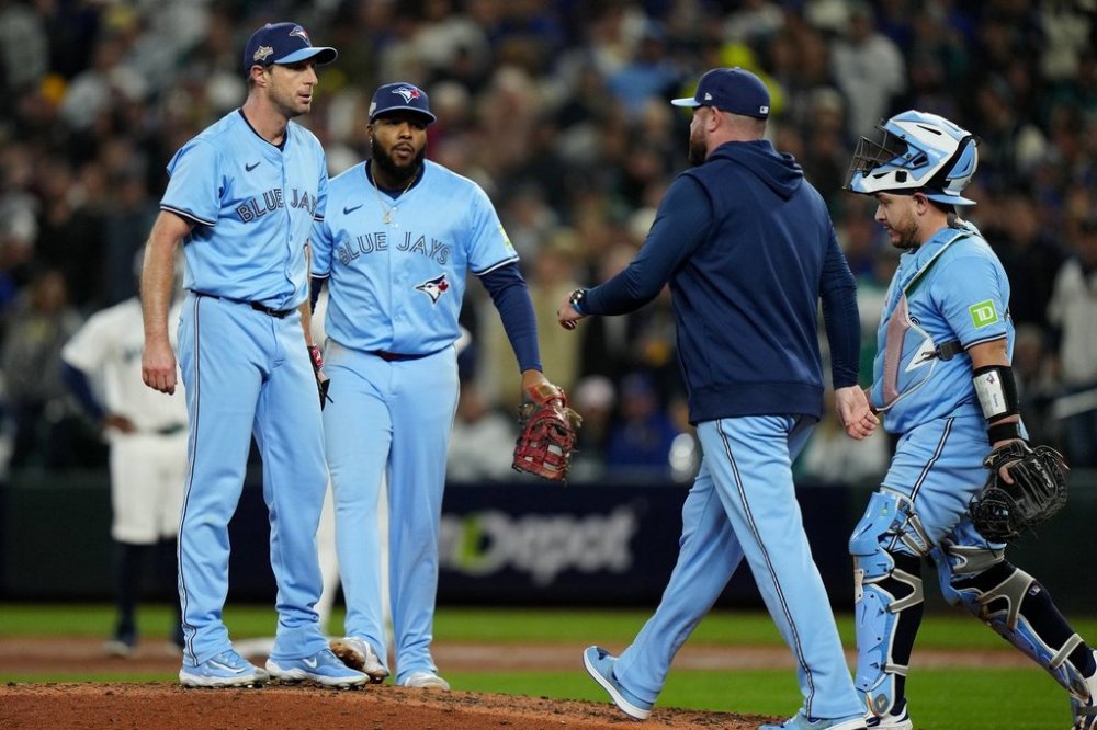 Toronto Blue Jays pitcher Max Scherzer (31) looks on as Jays manager John Schneider makes a visit to the mound during fifth inning MLB American League Championship Series game 4 baseball action against the Seattle Mariners, in Seattle, Thursday, Oct. 16, 2025. THE CANADIAN PRESS/Frank Gunn