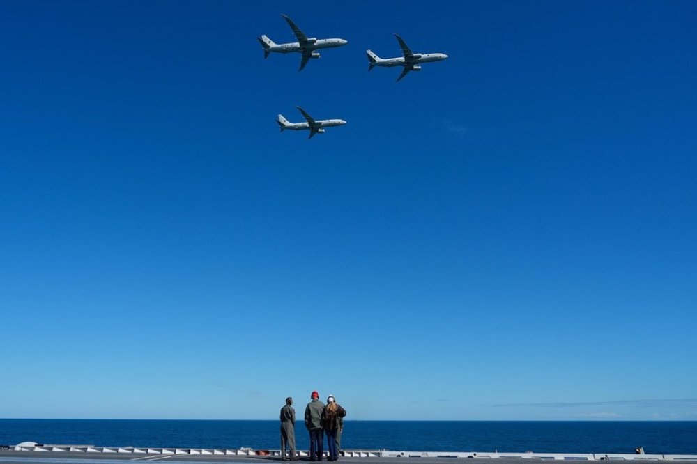 President Donald Trump and first lady Melania Trump watch a flight of P-8A Poseidon aircraft during a naval sea power demonstration, part of the Navy's 250th anniversary celebration, aboard the USS George H.W. Bush aircraft carrier in the Atlantic Ocean off the coast of Norfolk, Va., Sunday, Oct. 5, 2025. (AP Photo/Alex Brandon)