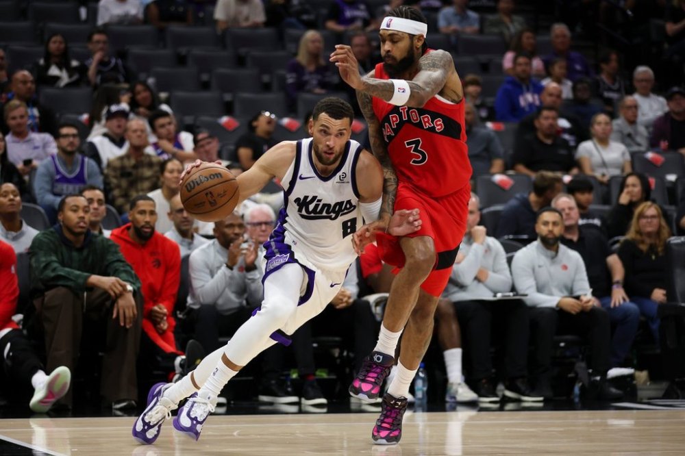 Sacramento Kings guard Zach LaVine (8) dribbles by Toronto Raptors forward Brandon Ingram (3) during the first half of an NBA basketball pre-season game Wednesday, Oct. 8, 2025, in Sacramento, Calif. (AP Photo/Scott Marshall)
