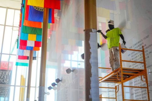 Odden Shaw painting over a gold coloured column inside the Hall of Nations at the Kennedy Center for Performing Arts in Washington, Friday, Oct. 24, 2025, in preparation for upcoming FIFA World Cup 2026 Final Draw. (AP Photo/Pablo Martinez Monsivais)