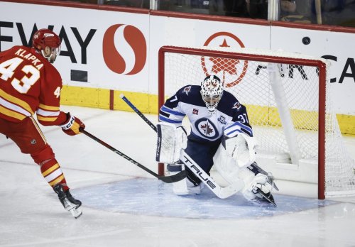 Winnipeg Jets goalie Connor Hellebuyck (37) guards the net as Calgary Flames' Adam Klapka shoots wide during second period NHL hockey action in Calgary, Alta., Saturday, Nov. 15, 2025. THE CANADIAN PRESS/Jeff McIntosh