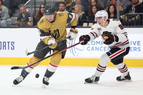 Vegas Golden Knights defenseman Kaedan Korczak (6) and Chicago Blackhawks right wing Ilya Mikheyev (95) contest for a loose puck during the first period of an NHL hockey game Tuesday, Dec. 2, 2025, in Las Vegas. (AP Photo/Ian Maule)