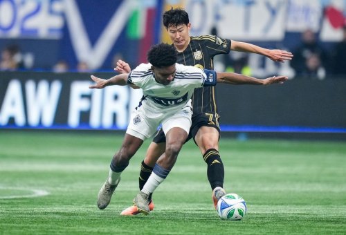 Vancouver Whitecaps' Ralph Priso, front, and Los Angeles FC's Son Heung-min vie for the ball during the first half of the MLS Western Conference semifinal playoff soccer match, in Vancouver, on Saturday, November 22, 2025. THE CANADIAN PRESS/Darryl Dyck