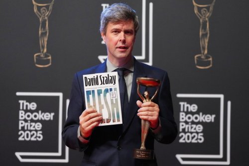 Hungarian-British author David Szalay poses for photographers with the trophy after winning the Booker Prize 2025 for his book 'Flesh' during a ceremony at Old Billingsgate in London, Monday, Nov. 10, 2025. (AP Photo/Kirsty Wigglesworth)