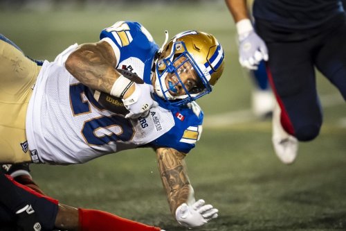 Winnipeg Blue Bombers' Brady Oliveira (20) is tripped up during second half CFL action against the Montreal Alouettes, in Montreal on Thursday, Aug. 21, 2025. THE CANADIAN PRESS/Christopher Katsarov