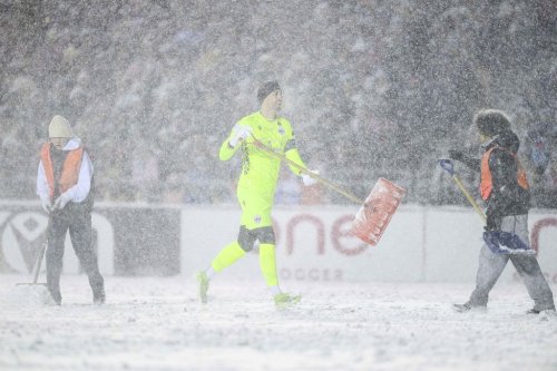 Atletico Ottawa's Nathan Ingham (29) carries a snow shovel following a break in play as officials work to clean soccer pitch lines during first half Canadian Premier League finals soccer action in Ottawa, on Sunday, Nov. 9, 2025. THE CANADIAN PRESS/Spencer Colby