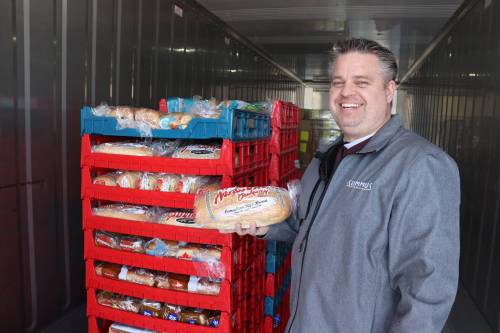 Dzogan holds up a loaf of bread inside one of the Food Rescue Grocery Store&rsquo;s refrigerated storage units in 2023. The not-for-profit business&rsquo;s use of shipping containers as refrigerated storage units has spread to Winnipeg under a charity that just installed two. (Kyle Darbyson/The Brandon Sun files)