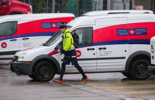 A Canada Post employee returns to a delivery depot in Vancouver, B.C., late last year. (The Canadian Press files)
