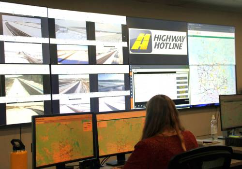 Inside the Saskatchewan Highway Hotline office, a staffer keeps watch of more than a dozen computer windows linked up to road cameras, maps and management systems. (Photo courtesy of Highway Hotline)