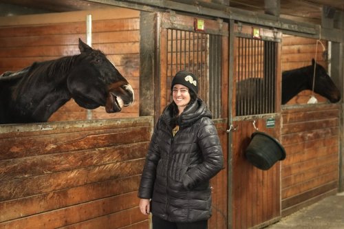 Alexandra Rose, a Facilitated Equine Experiential Learning (FEEL) worker stands in the barn at LongRun Thoroughbred Retirement Society, in Hillsburgh, Ont., on Friday, Nov. 21, 2025. THE CANADIAN PRESS/Chris Young
