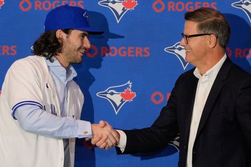 Dylan Cease pitcher for the Toronto Blue Jays shakes hands with Ross Atkins general manager of the Toronto Blue Jays, after he was presented with a team hat and jersey during a news conference at the Major League Baseball's winter meetings, Tuesday, Dec. 9, 2025, in Orlando, Fla. (AP Photo/John Raoux)