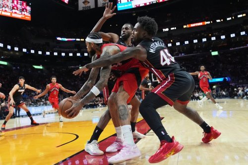 Miami Heat forward Andrew Wiggins, left, and guard Davion Mitchell (45) defend Toronto Raptors forward Brandon Ingram, centre, during the second half of an NBA basketball game, Monday, Dec. 15, 2025, in Miami. (AP Photo/Lynne Sladky)
