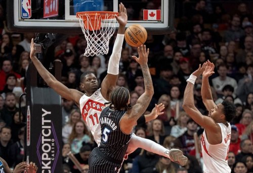 Toronto Raptors centre Mo Bamba (11) and forward Scottie Barnes (right) defend against Orlando Magic forward Paolo Banchero (5) as he shoots during first half NBA action in Toronto on Monday December 29, 2025. THE CANADIAN PRESS/Frank Gunn