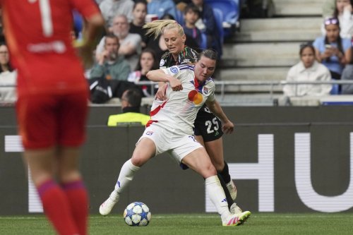 Arsenal's Stina Blackstenius, background, fights for the ball with Lyon's Vanessa Gilles during the women's Champions League semifinals, second leg, soccer match between Olympique Lyonnais and Arsenal at OL Stadium in Decines, outside Lyon, France, Sunday, April 27, 2025. (AP Photo/Thibault Camus)