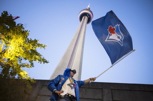 Tadziu Krawiec waves a flag outside the Rogers Centre ahead of Game 7 of the World Series between the Toronto Blue Jays and Los Angeles Dodgers in Toronto on Nov. 1, 2025. THE CANADIAN PRESS/Nick Iwanyshyn