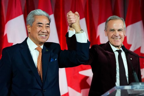 Prime Minister Mark Carney raises the hand of Michael Ma, Member of Parliament for Markham-Unionville, who crossed the floor from the Conservatives to the Liberals this week. Carney seems to be benefitting from occupying the middle of the political spectrum. (The Canadian Press files)