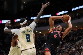 Toronto Raptors' Scottie Barnes (4) shoots against Milwaukee Bucks' Bobby Portis (9) during the first half of an NBA basketball game, Thursday, Dec. 18, 2025, in Milwaukee. (AP Photo/Aaron Gash)