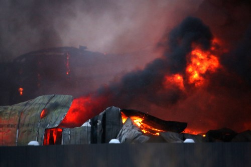 A fire burns at a storage and equipment shop owned by Full Tilt Towing & Transport at 49th St. East on Saturday morning. No one was injured in the blaze. (Matt Goerzen/The Brandon Sun)