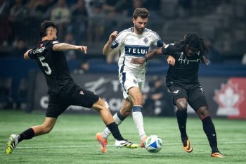 Vancouver FC's Matteo Campagna, left, Kunle Dada-Luke, right and Vancouver Whitecaps' Thomas Muller, centre, vie for the ball during the first half of the Canadian Championship final soccer match, in Vancouver, on Wednesday, October 1, 2025. THE CANADIAN PRESS/Ethan Cairns