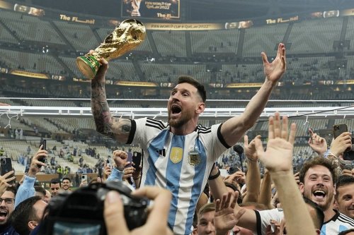 FILE — Argentina's Lionel Messi celebrates with the trophy in front of the fans after winning the World Cup final soccer match between Argentina and France at the Lusail Stadium in Lusail, Qatar, Sunday, Dec. 18, 2022. Lionel Messi has been named FIFA’s best men’s player after moving to Inter Miami and leading the team to a little-known Leagues Cup title, all while single-handedly elevating soccer’s relevance in the United States. The 36-year-old Argentina star on Monday was selected over Kylian Mbappe and Erling Haaland — the same pair he beat for his eighth Ballon d’Or award last October. (AP Photo/Martin Meissner, File)