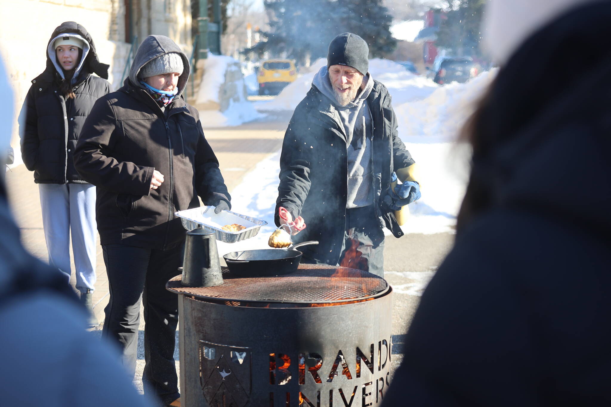 BU students gather for bannock cooked over fire