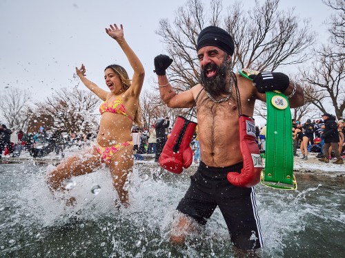 Pardeep Singh Nagra, right, runs into the frigid water as he takes part in a New Year's Day polar bear dip at Sunnyside beach in Toronto, on Thursday, Jan. 1, 2026. THE CANADIAN PRESS/Sammy Kogan